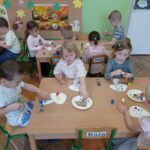 dzieci naklejają kropki na szblon grzyna