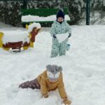 dwoje dzieci bawi się na śniegu