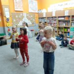 kilkoro dzieci stoi na dywanie