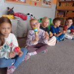 kilkoro dzieci trzyma w ręku grzechotki