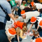 rodzice i dzieci wypełniają na dywanie kartę pracy