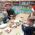 rodzina siedzi przy stole i wykonuje renifera