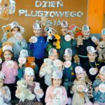 Dzieci pozują do zdjęcia grupowego z misiami i medalami