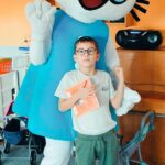 Chłopiec pozuje z Kicią Kocią