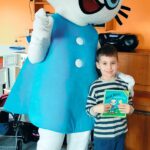 Chłopiec pozuje z Kicią Kocią