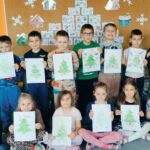 Zdjęcie grupowe z narysowanymi przez dzieci choinkami