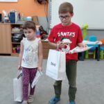 chłopiec i dziewczynka stoją i trzymają nagrody