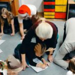 rodzice i dzieci wypełniają na dywanie kartę pracy