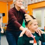 dzieci w opaskach reniferów prowadzą rodziców