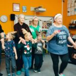 dzieci w opaskach reniferów prowadzą rodziców