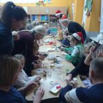 grupa rodziców i dzieci siedzi przy stolikach