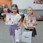 dwie dziewczynki pokazują dyplomy