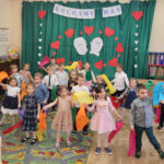 Dzieci tańczą taniec z kolorowymi chustkami